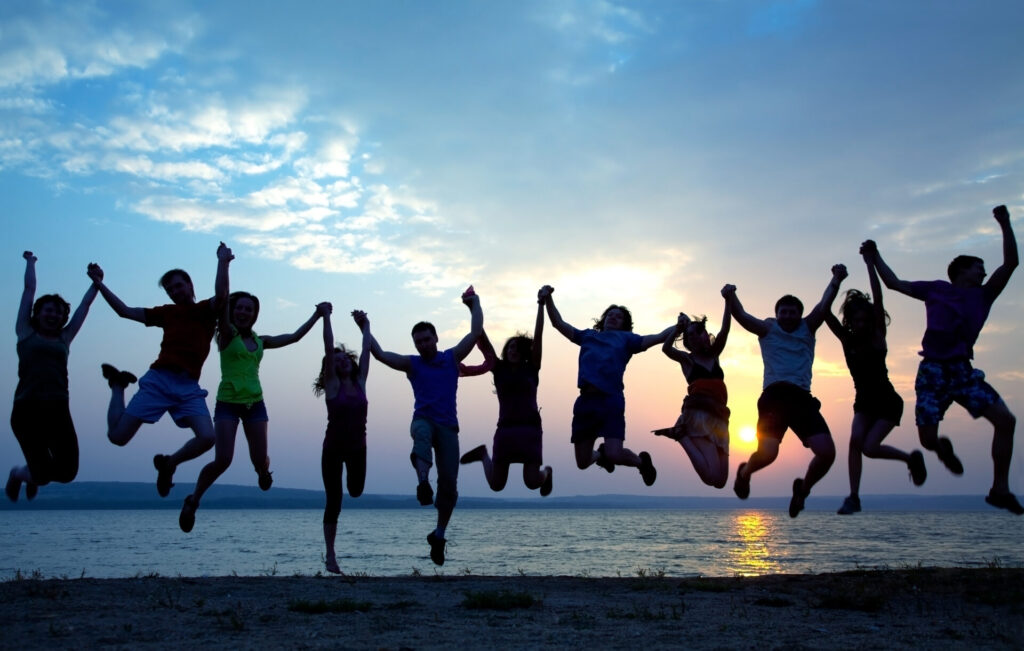 group of people holding hands and posed for a jump shot, overseas retreat
