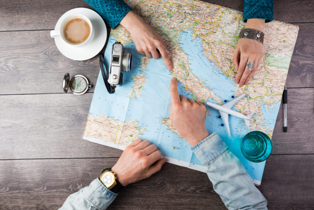 people planning on a trip with world map, coffee and camera