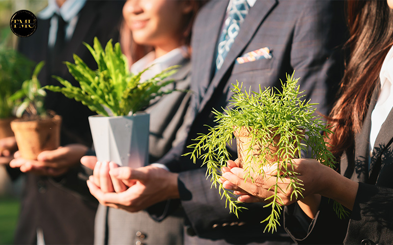 Business professionals holding potted plants for an eco-friendly event